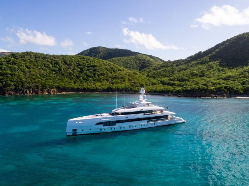 HOME yacht anchored near a remote Caribbean island, with crystal-clear waters and ultimate privacy.