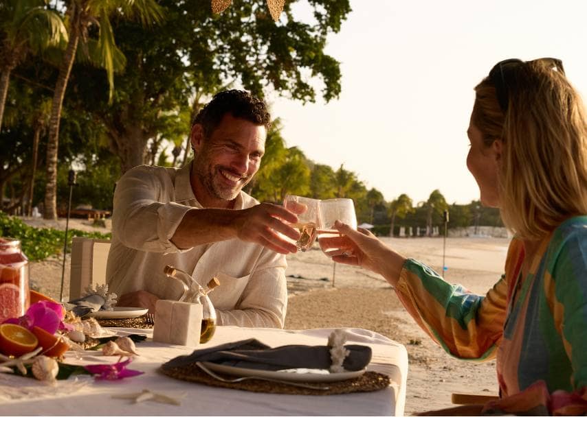 Couple savoring a romantic dinner on the beach during their luxury Caribbean yacht vacation.