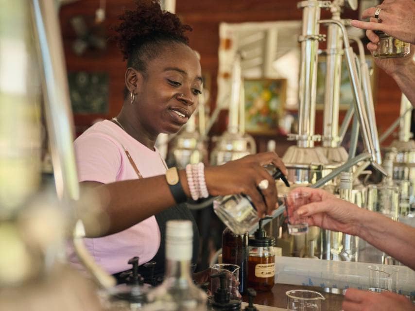 Bartender serving a cocktail for luxury yacht charter guests during caribbean festivals.