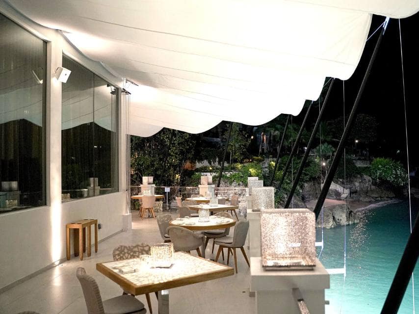 A serene table overlooking the water is set for a night of elevated cuisine at The Cliff, Barbados, ideal for a luxury Caribbean yacht charter stop.