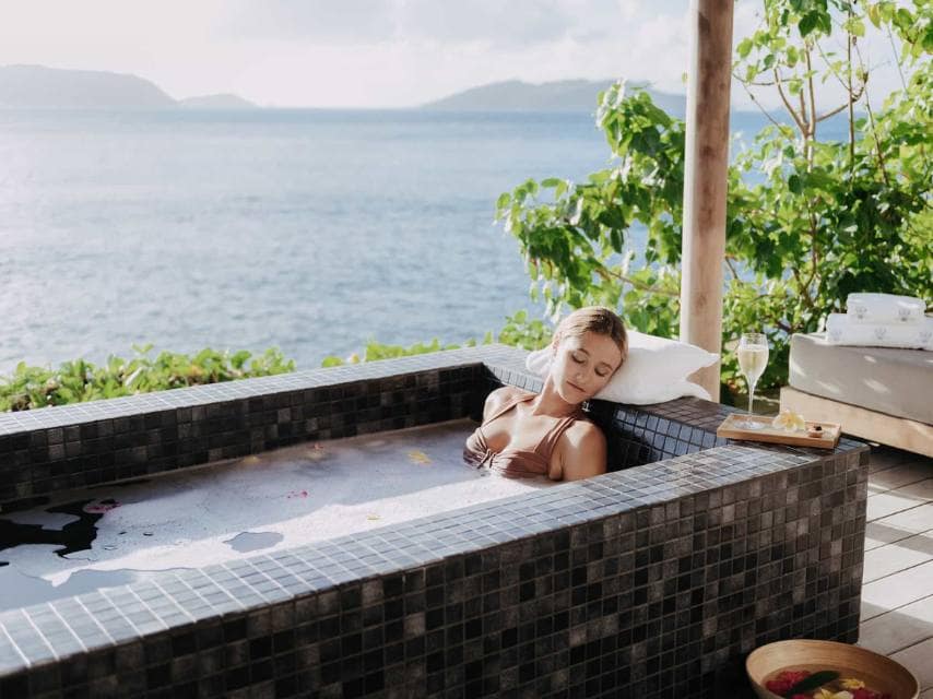 Calm spa retreat Caribbean style relaxation is captured with a woman unwinding in Spa Sisley’s private jacuzzi.