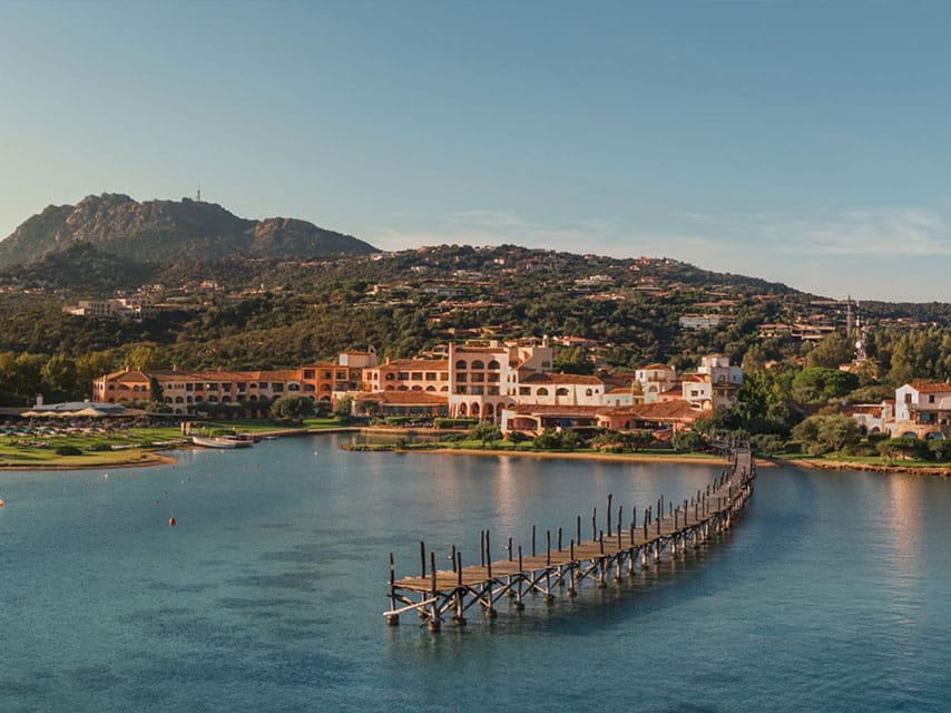 Ultra luxury yacht charter Mediterranean guests enjoy this view of terracotta terraces and turquoise waters in Cala di Volpe.