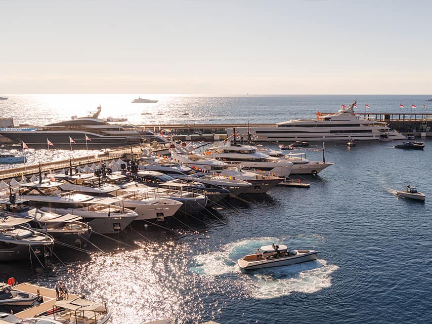 Exclusive yacht charter events include the Monaco yacht show pictured here showing sun-drenched luxury yachts neatly berthed.