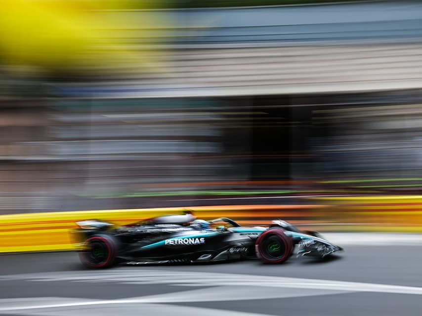 An F1 car races along the track – an electrifying view from a yacht charter Monaco Grand Prix experience.