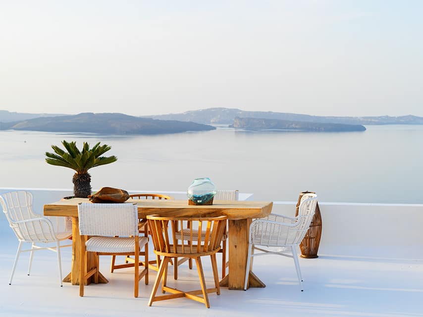 A Santorini yacht charter offers alfresco dining on a terrace overlooking the caldera and volcanic islets.
