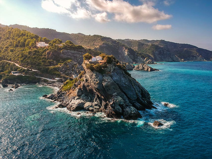 AA Sporades yacht charter passes Skopelos clifftop Agios Ioannis chapel, made famous in the film Mamma Mia.