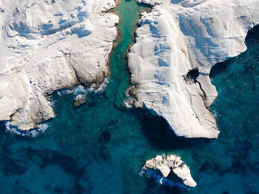 Greece superyacht charter guests admire Milos, where turquoise Cyclades water meets the white cliffs of Sarakiniko.