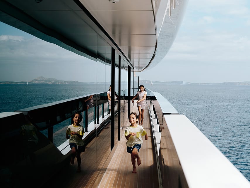 Greece superyacht charter guests run along the deck of the 102m Lurssen superyacht NIXIE.