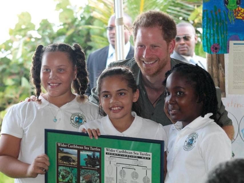 Prince Harry taking a photo with children attending the sea turtle charity