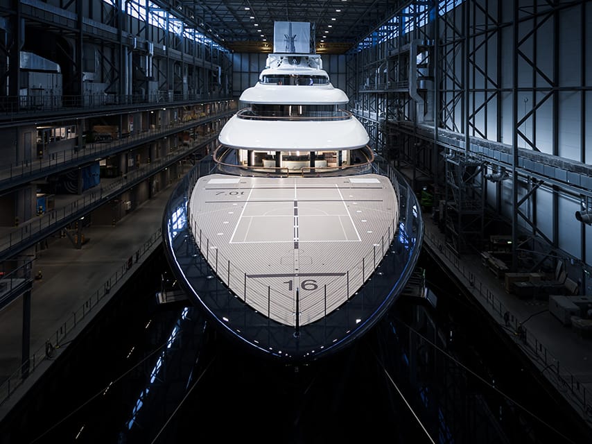 The luxury Feadship 821 for sale in a modern shipyard, showcasing its sleek design.
