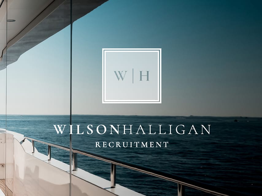 Yacht deck with Wilsonhalligan logo, symbolizing luxury yacht careers and crew recruitment expertise.