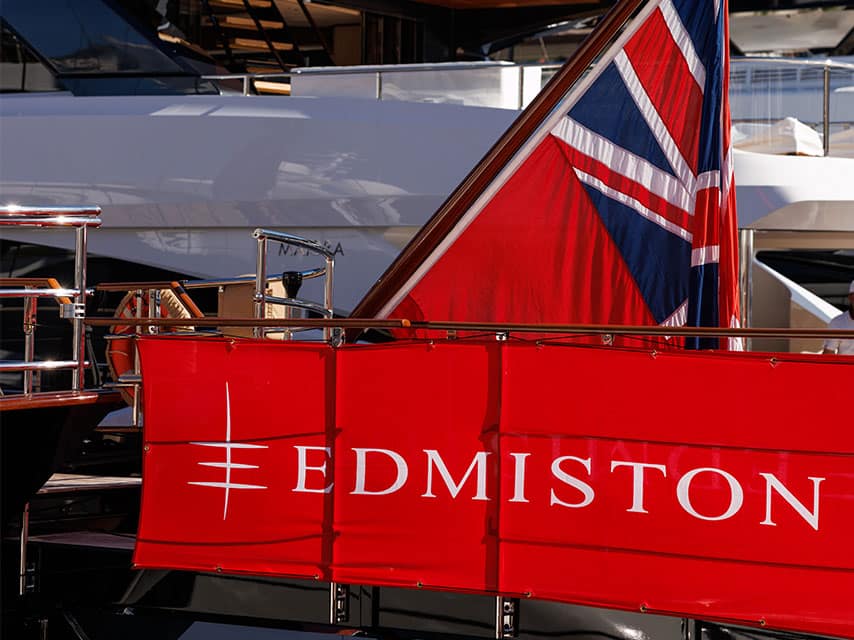 MYBA yacht show display featuring the iconic red Edmiston banner and a brilliant British ensign flag on a luxury yacht tender.