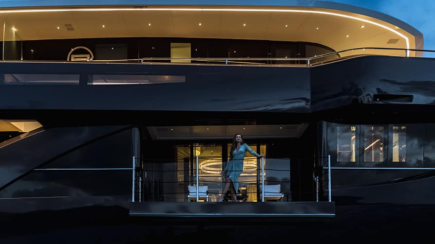 A woman enjoys a luxury experience on the deck of her yacht build, designed to her specifications.