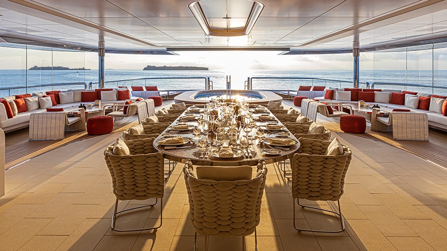 A sophisticated yacht dining table, prepared for guests, to sell your yacht with expert guidance from Edmiston superyacht brokers.