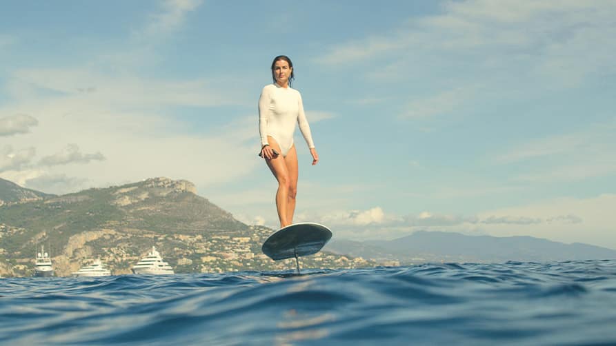 A woman hovering over the water on her superyacht toy