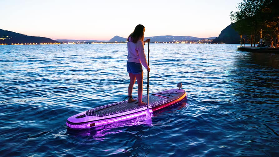 A teenage girl paddling on a glow-in-the-dark water toy for yachts