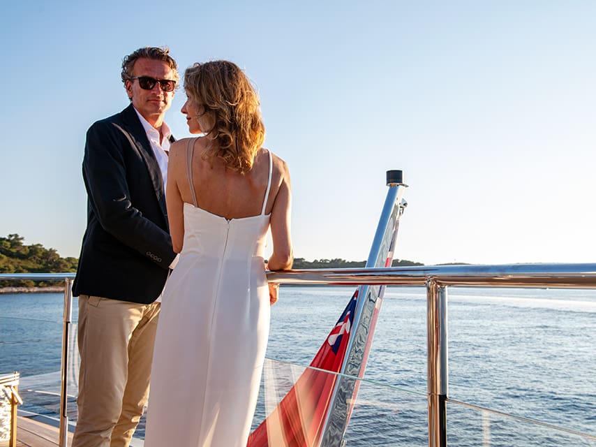 A couple enjoys the view from the deck of their French Riviera yacht charter.