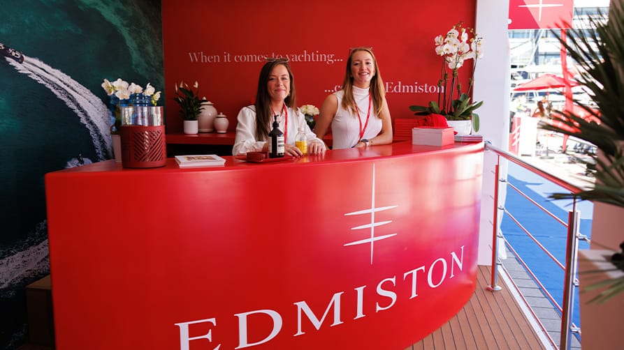 Smiling Edmiston staff greet yachters arriving at the 2024 Monaco Yacht Show with a warm welcome at the Edmiston kiosk.