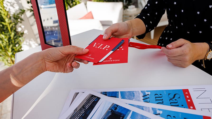 An Edmiston staff member hands a VIP ticket to a client, who is ready to enjoy the many VIP advantages at the Monaco Yacht Show 2024.