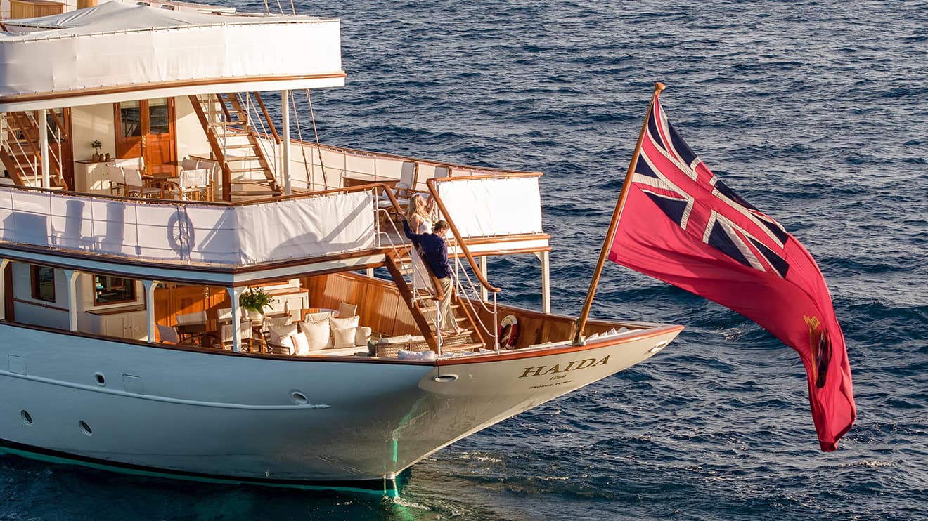 Haida yacht charter with a British flag flowing in the wind
