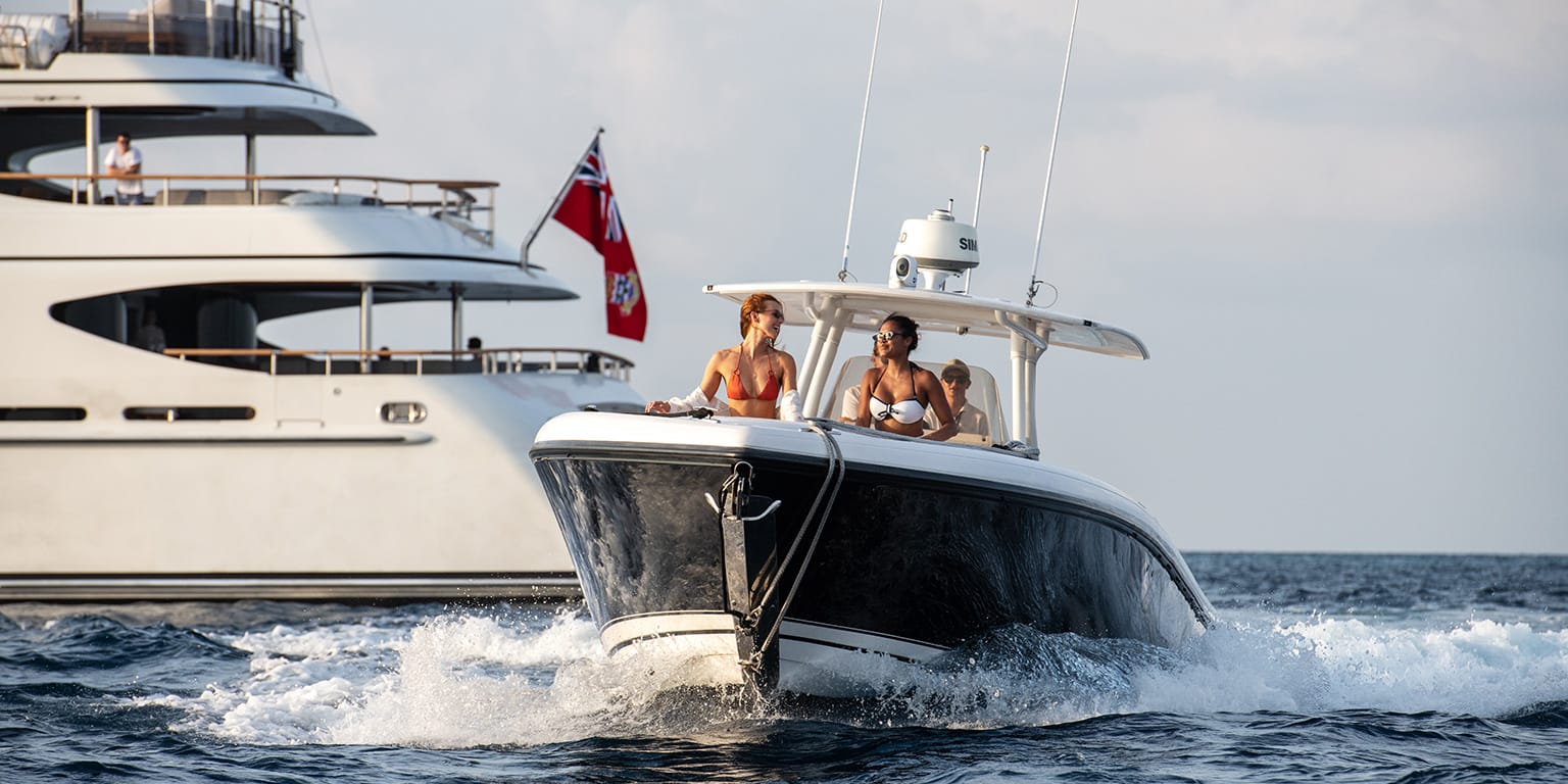 Two people riding a motor boat from their luxury yacht charter