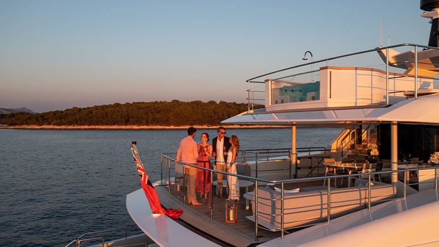 Friends gather on deck to enjoy a glass of yacht wine together.