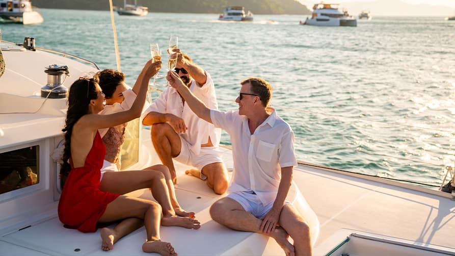 Friends raise a glass to their luxurious superyacht lifestyle.