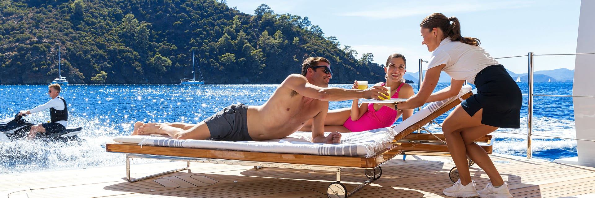 couple-enjoys-drinks-while-sunlounging-on-yacht